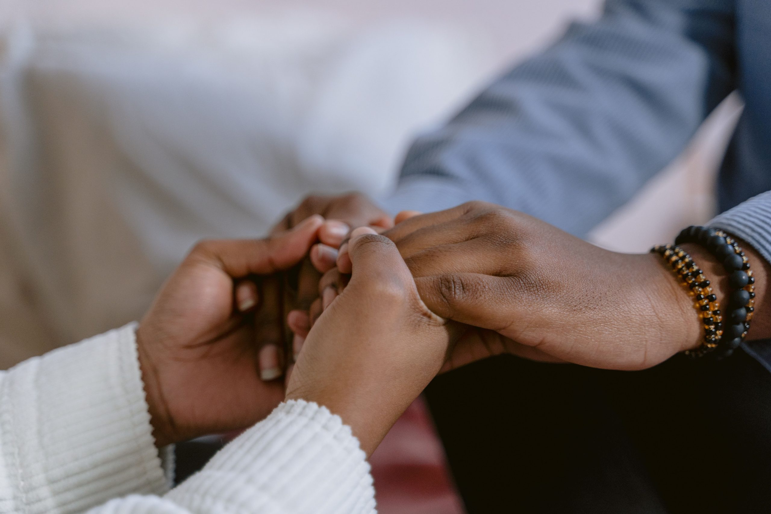 Two people holding hands in a gesture of support during a health challenge