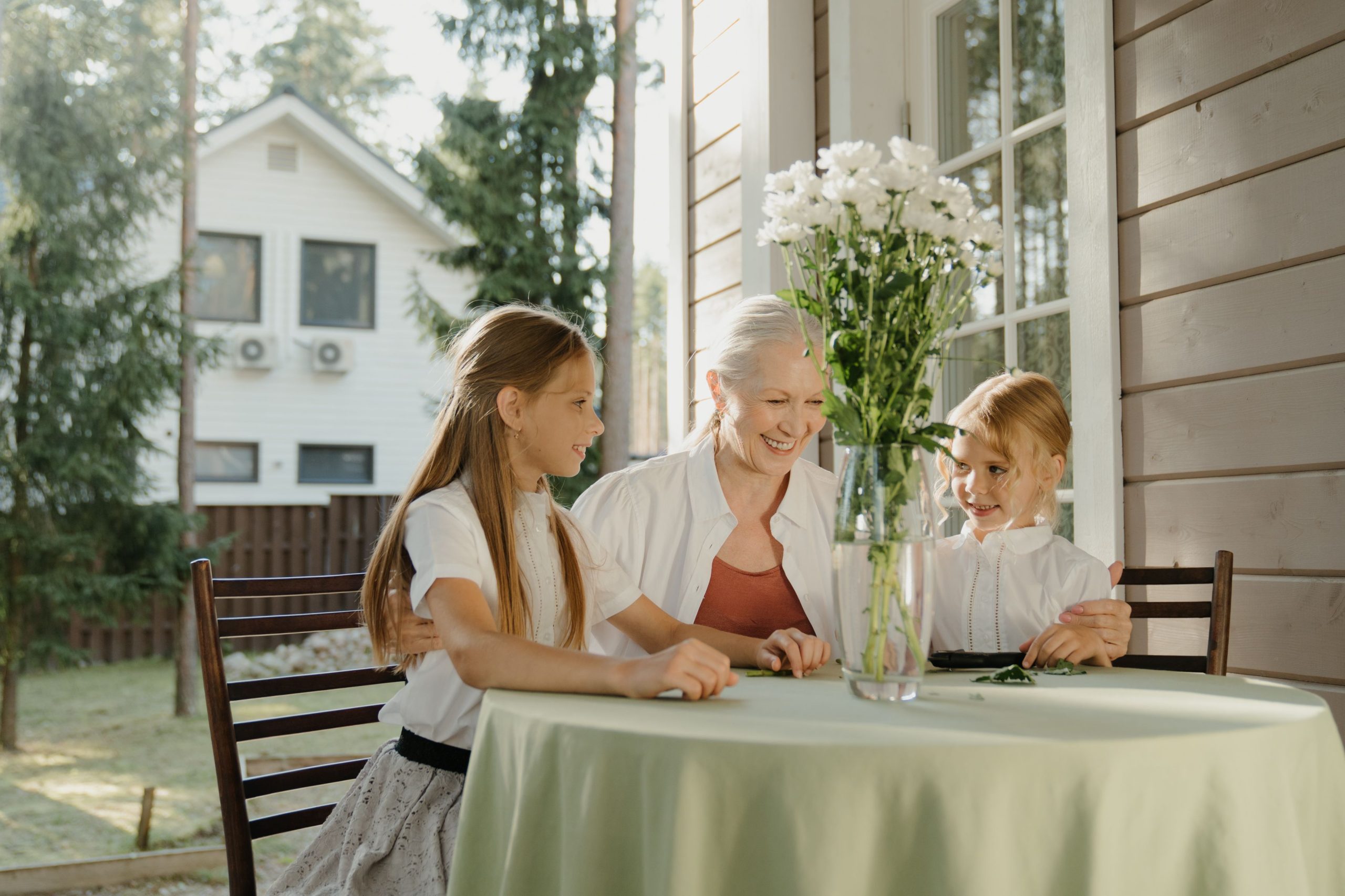 Grandmother sitting with two grandchildren on a porch in British Columbia